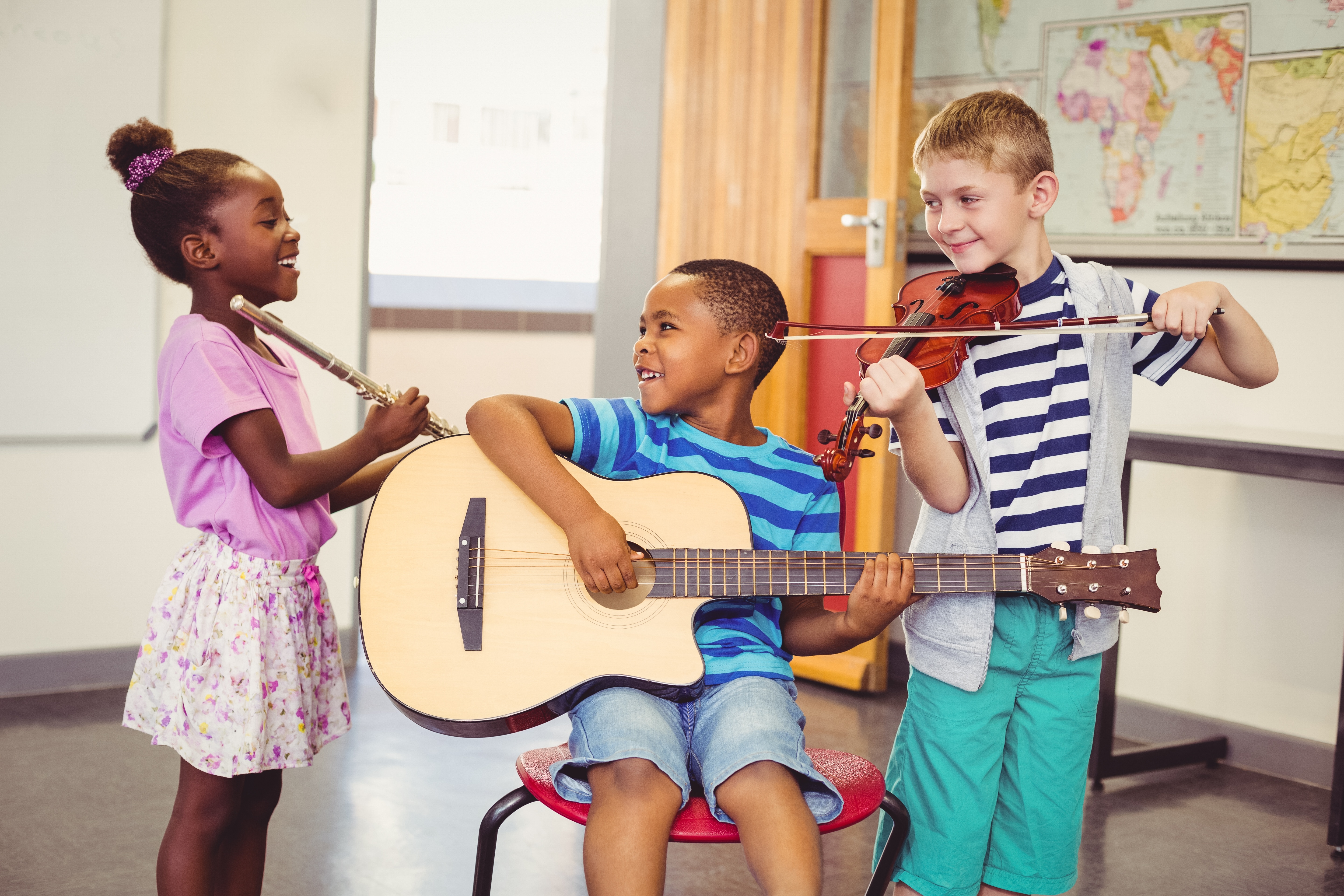 Children laughing and playing with musical instruments after taking a test