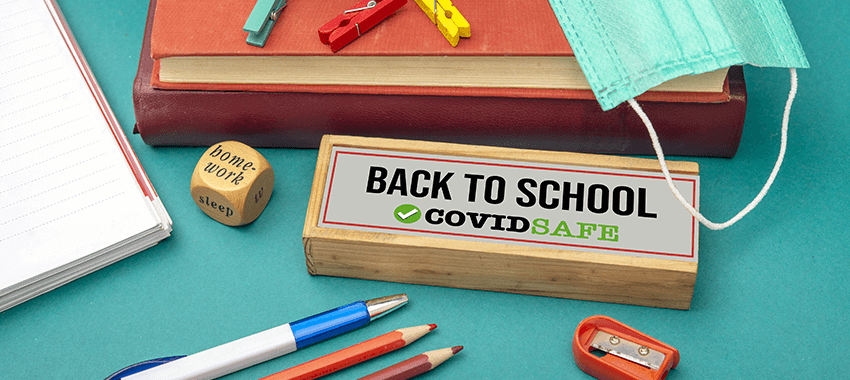 Desk with Back-to-School Covid teaching supplies and face masks
