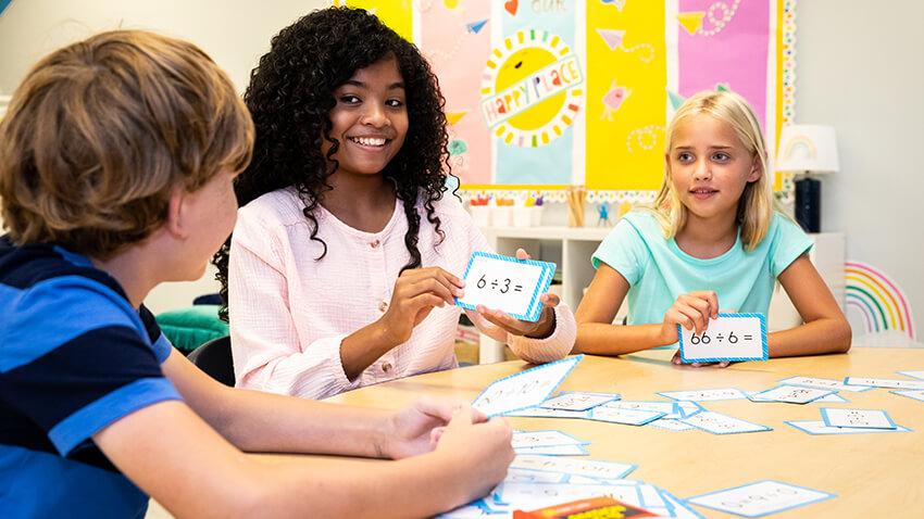 Students practicing division with flash cards