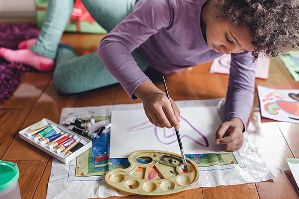 Child doing arts and crafts with paint and markers