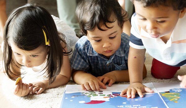 Photo of small children reading a children's book