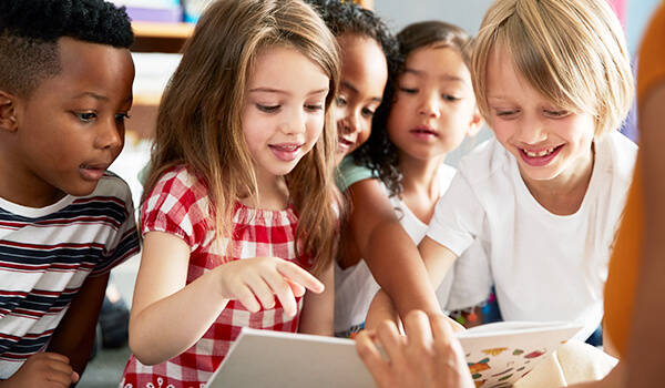 Teacher showing school children Katie Can series books