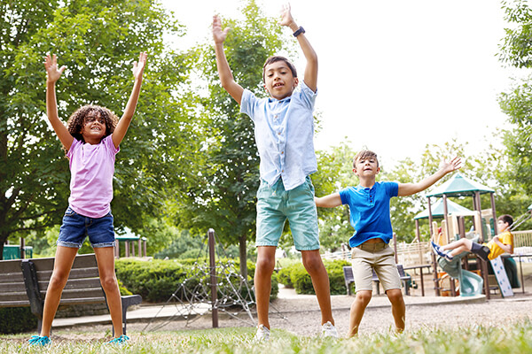 Children outside doing jumping jacks during Spring Break