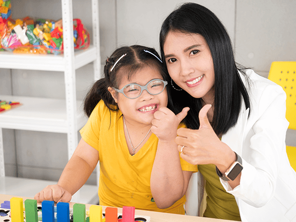 Teacher and student in classroom giving thumbs up Teacher and student in classroom giving thumbs up